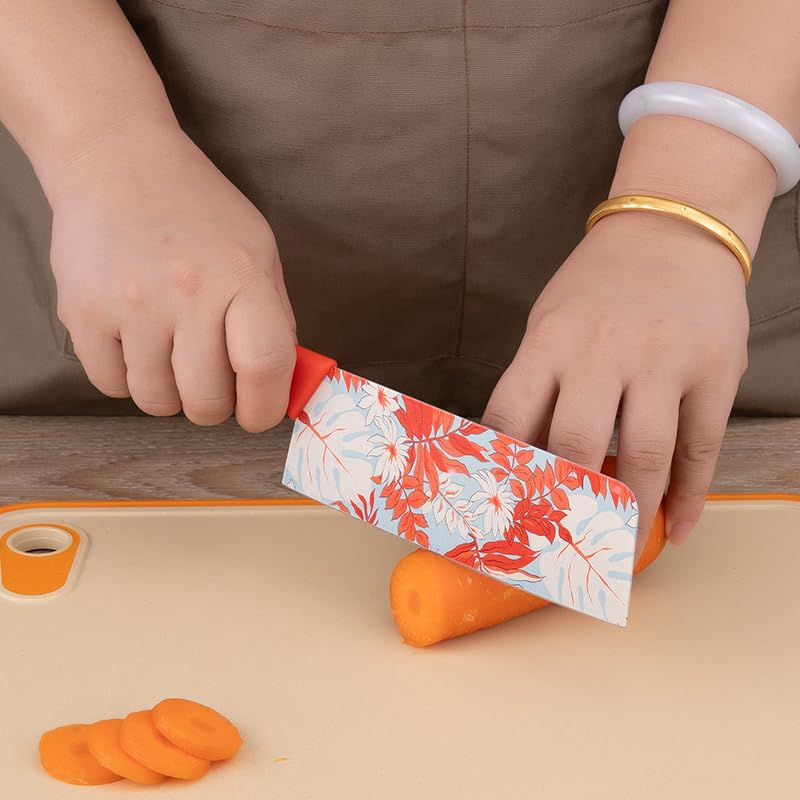 Person using a floral-patterned knife to slice carrots on a wooden cutting board.
