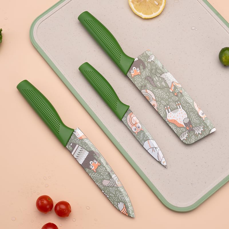 Two green-handled knives with patterned blades on a cutting board with vegetables.